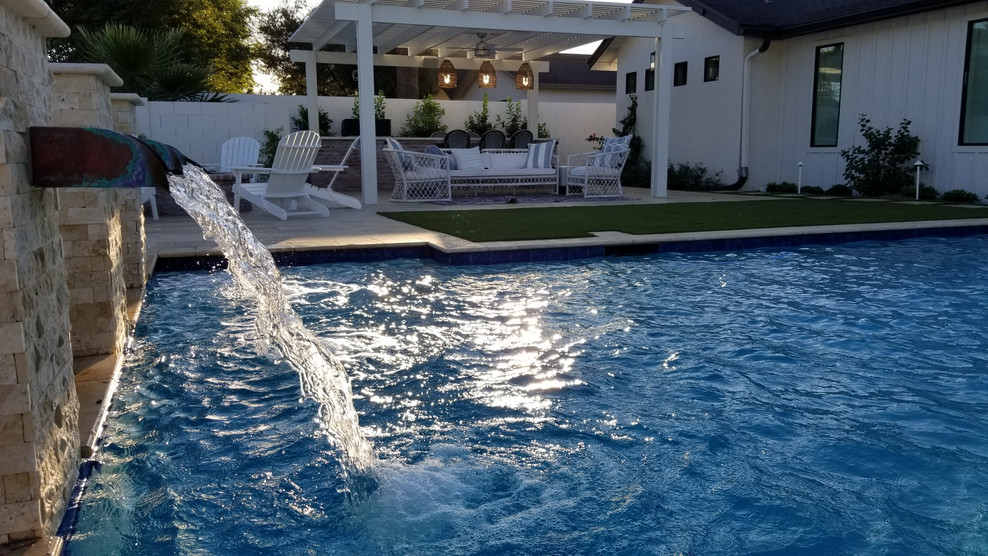 Réalisation d'une piscine arrière champêtre de taille moyenne et rectangle avec un point d'eau et du carrelage.