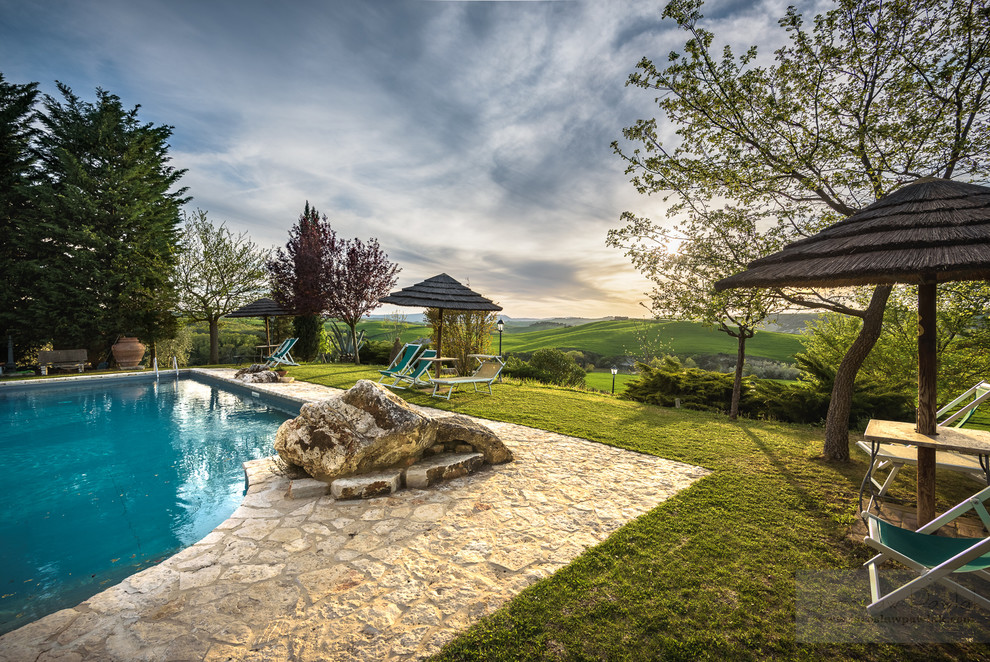 Idee per una piscina fuori terra mediterranea rettangolare di medie dimensioni e dietro casa con una dépendance a bordo piscina e pavimentazioni in pietra naturale