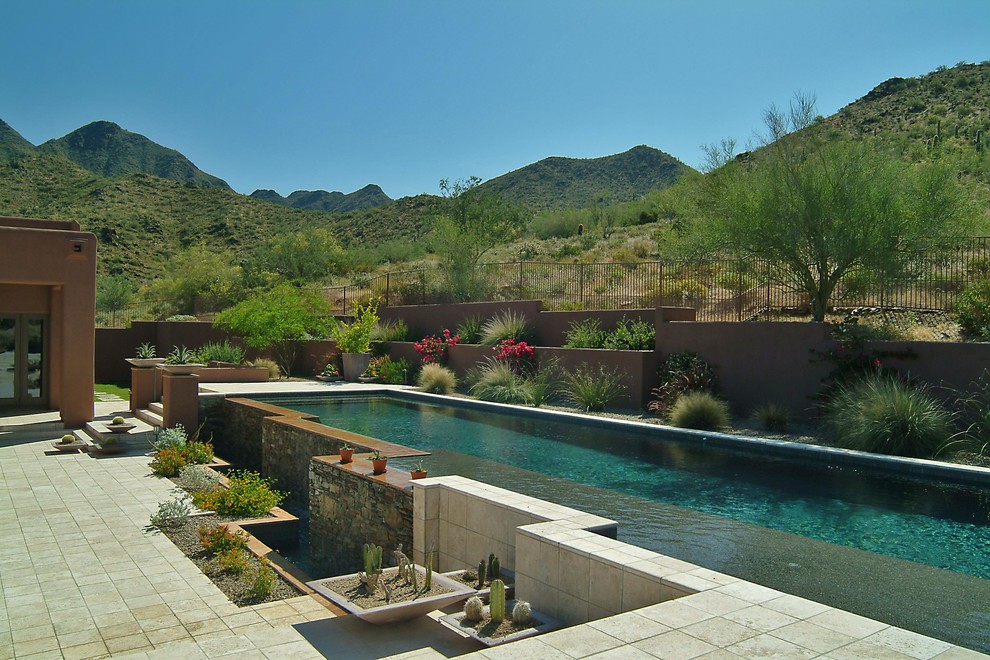 Свежая идея для дизайна: прямоугольный бассейн-инфинити среднего размера на заднем дворе в средиземноморском стиле с покрытием из каменной брусчатки - отличное фото интерьера