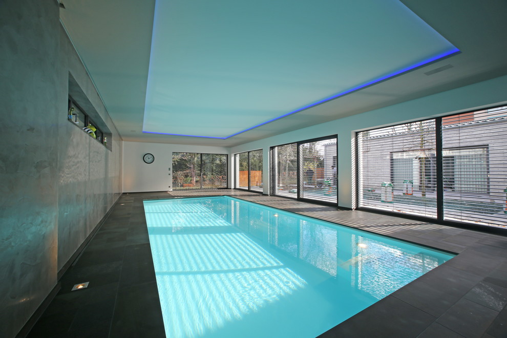 На фото: прямоугольный бассейн среднего размера в доме в стиле модернизм с домиком у бассейна