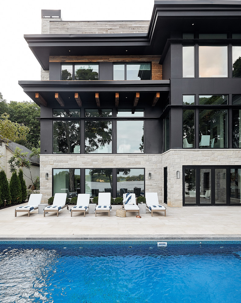 Esempio di una piscina design rettangolare dietro casa con pavimentazioni in pietra naturale