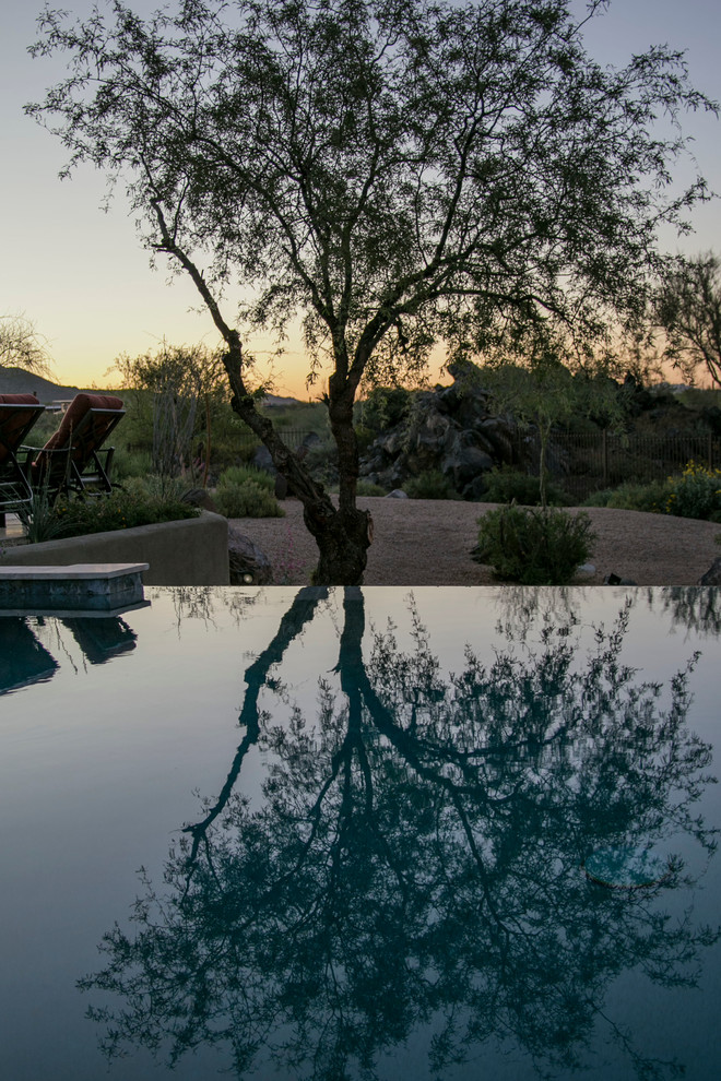 Esempio di una grande piscina naturale american style personalizzata dietro casa con una vasca idromassaggio e pavimentazioni in cemento