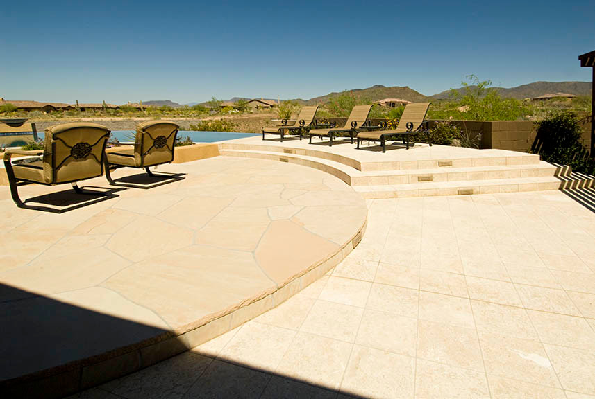 Diseño de piscina infinita de estilo americano grande a medida en patio trasero con adoquines de piedra natural