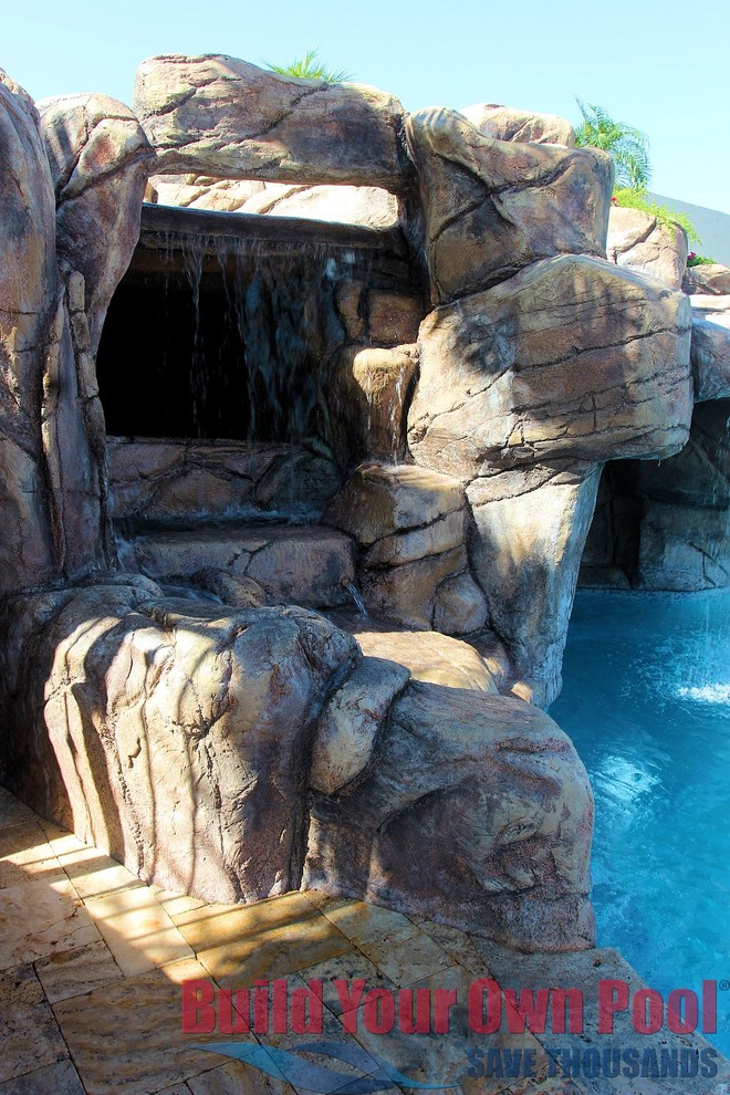 Immagine di una piscina tropicale personalizzata dietro casa con pavimentazioni in pietra naturale