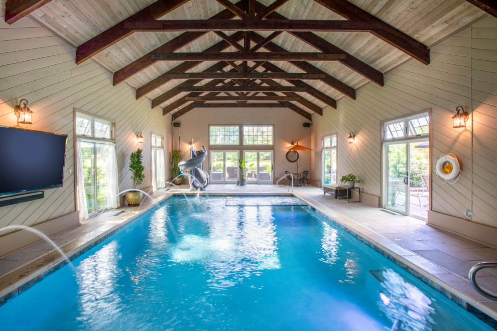 Ejemplo de casa de la piscina y piscina alargada tradicional de tamaño medio interior y rectangular con adoquines de piedra natural