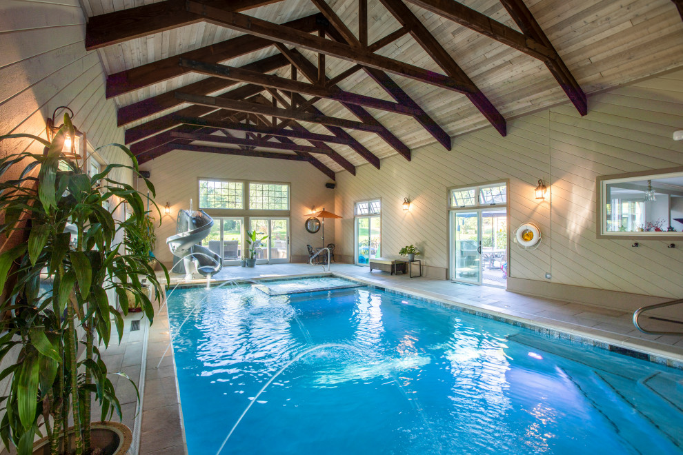 Ejemplo de casa de la piscina y piscina alargada tradicional de tamaño medio interior y rectangular con adoquines de piedra natural
