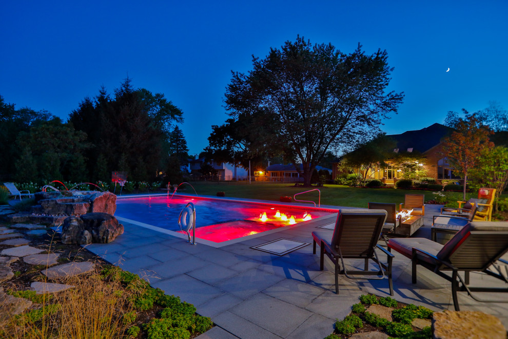 На фото: спортивный, прямоугольный ландшафтный бассейн среднего размера на заднем дворе в классическом стиле с покрытием из каменной брусчатки с