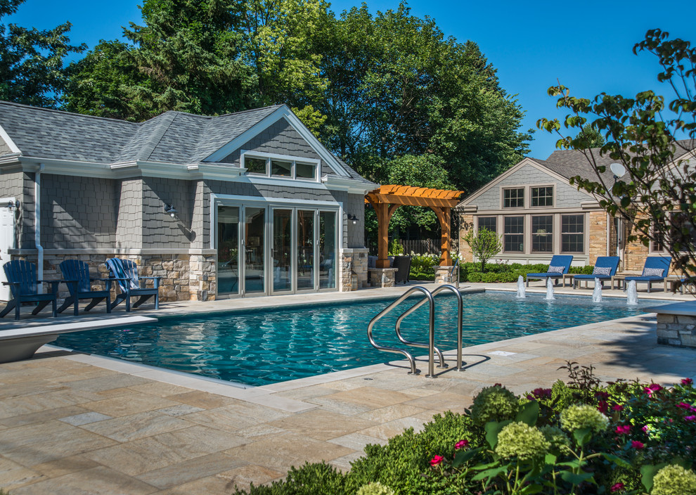 This is an example of a medium sized traditional back rectangular lengths swimming pool in Chicago with a pool house and concrete paving.