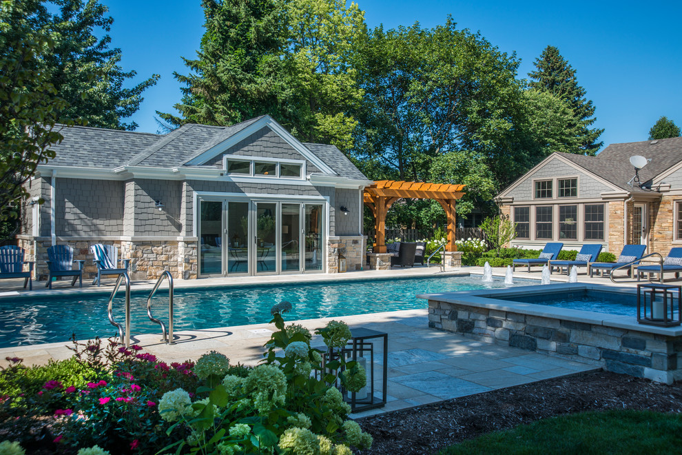 Ejemplo de casa de la piscina y piscina alargada clásica de tamaño medio rectangular en patio trasero con adoquines de hormigón