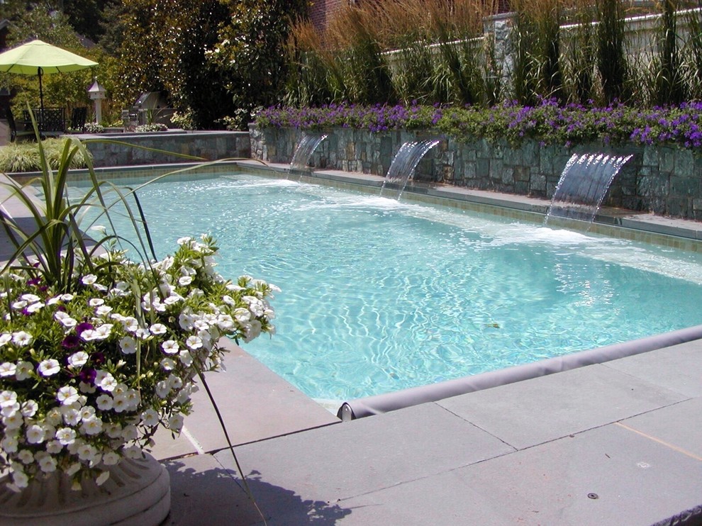 Ispirazione per una piscina monocorsia tradizionale rettangolare dietro casa e di medie dimensioni con una vasca idromassaggio e pavimentazioni in cemento