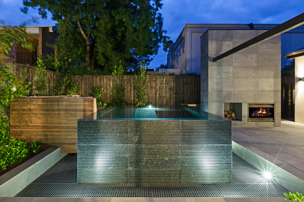 Esempio di una piscina a sfioro infinito moderna personalizzata di medie dimensioni e dietro casa