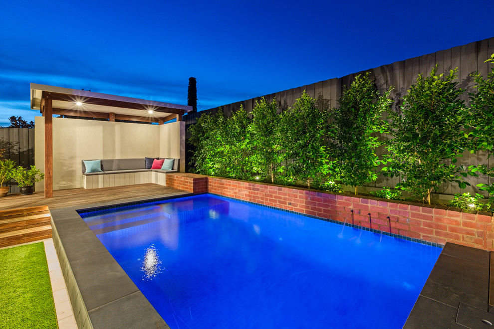 Foto de piscina con fuente elevada actual pequeña rectangular en patio trasero