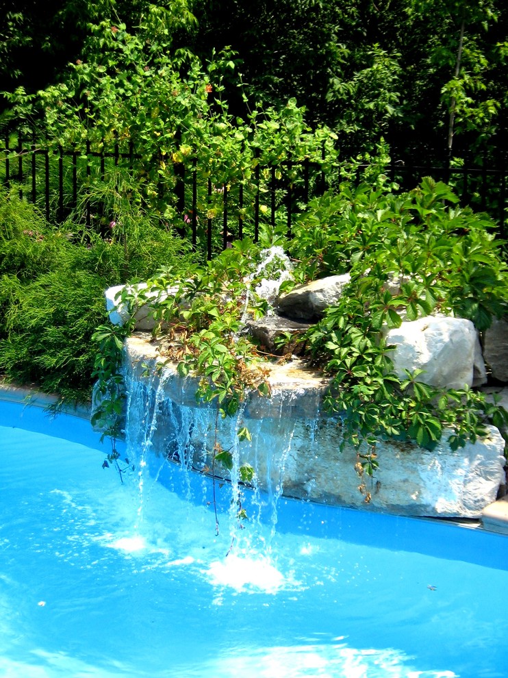 Pool fountain - mid-sized traditional backyard stone pool fountain idea in Toronto