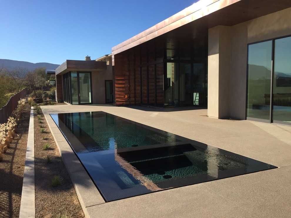 Свежая идея для дизайна: большой спортивный, прямоугольный бассейн на заднем дворе в стиле модернизм с покрытием из бетонных плит - отличное фото интерьера