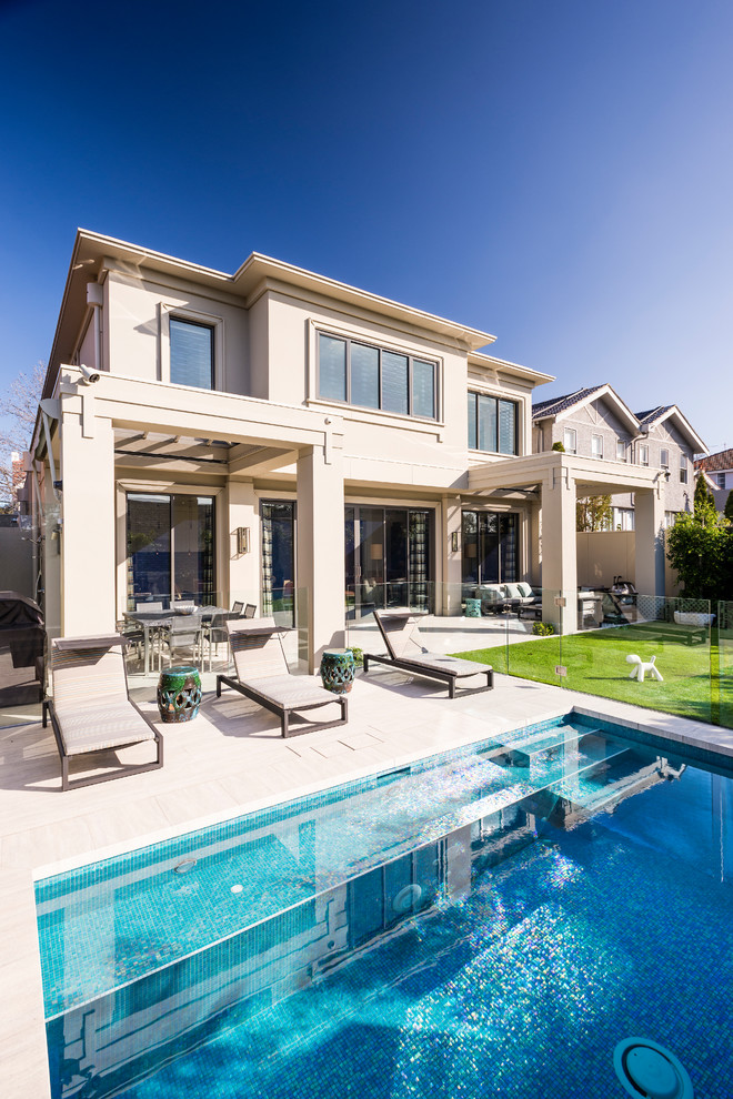 Example of a mid-sized backyard concrete paver and rectangular pool design in Melbourne