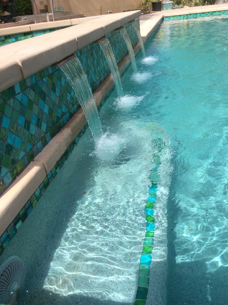 Imagen de piscinas y jacuzzis actuales grandes rectangulares en patio delantero con adoquines de hormigón