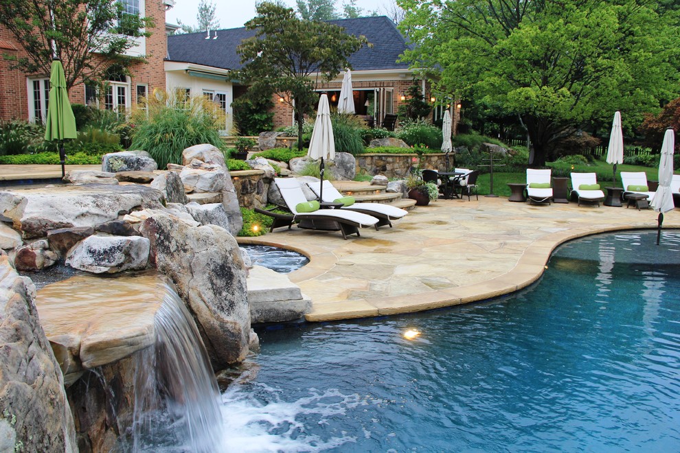 Example of a large transitional backyard stone and custom-shaped pool fountain design in DC Metro