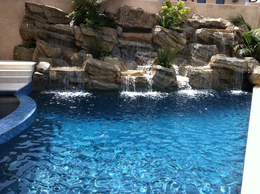 Immagine di una piscina monocorsia costiera rettangolare di medie dimensioni e dietro casa con fontane