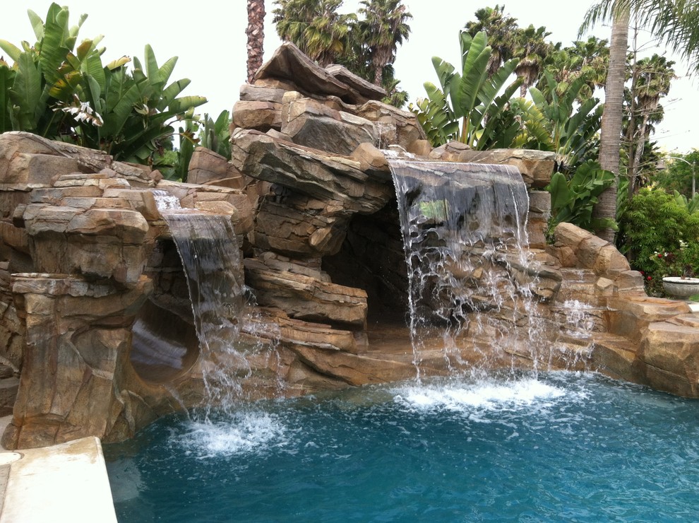 На фото: естественный бассейн произвольной формы на заднем дворе в стиле рустика с водной горкой с