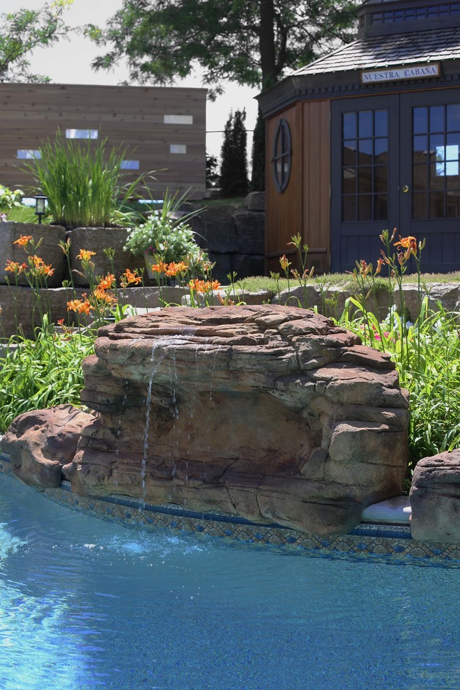 Foto di una piscina classica di medie dimensioni e dietro casa con fontane e pavimentazioni in pietra naturale