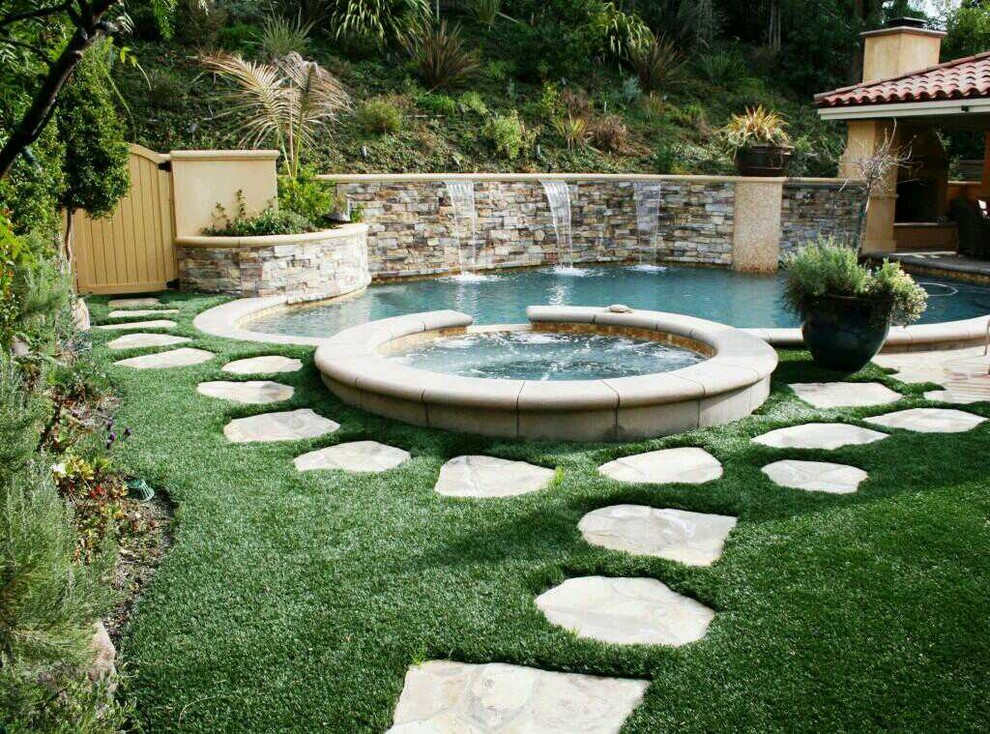 Modelo de piscinas y jacuzzis alargados rústicos de tamaño medio a medida en patio trasero con adoquines de piedra natural