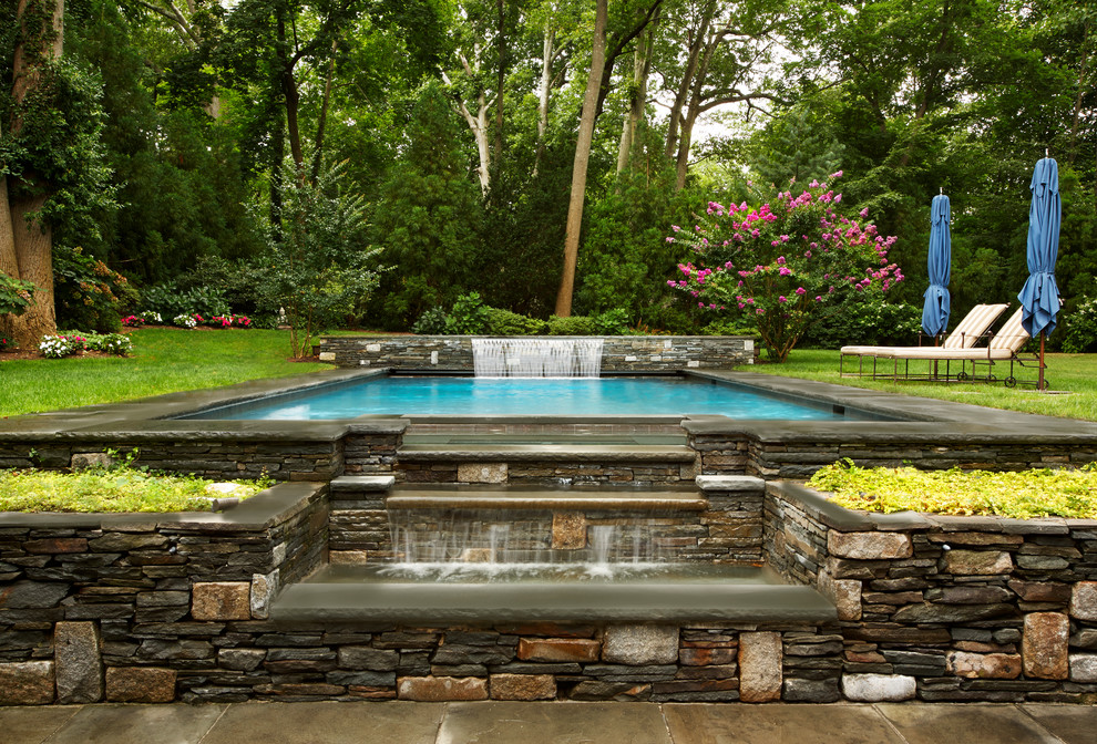Стильный дизайн: большой прямоугольный бассейн на заднем дворе в классическом стиле с фонтаном и покрытием из каменной брусчатки - последний тренд