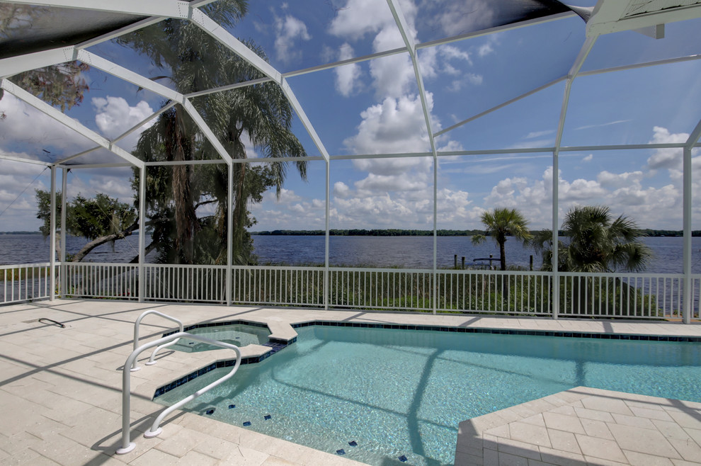 Foto di una grande piscina stile marino personalizzata dietro casa con pavimentazioni in pietra naturale