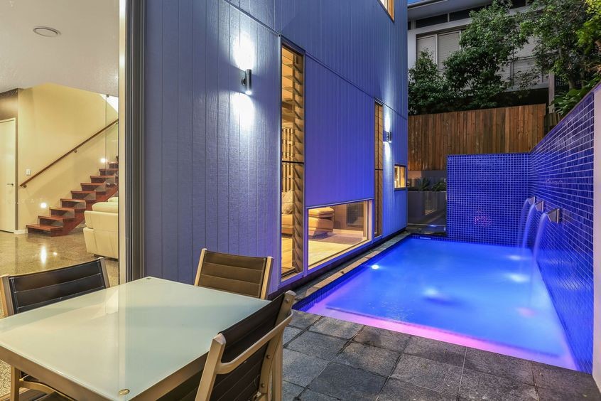 Small backyard stone and rectangular pool fountain photo in Brisbane