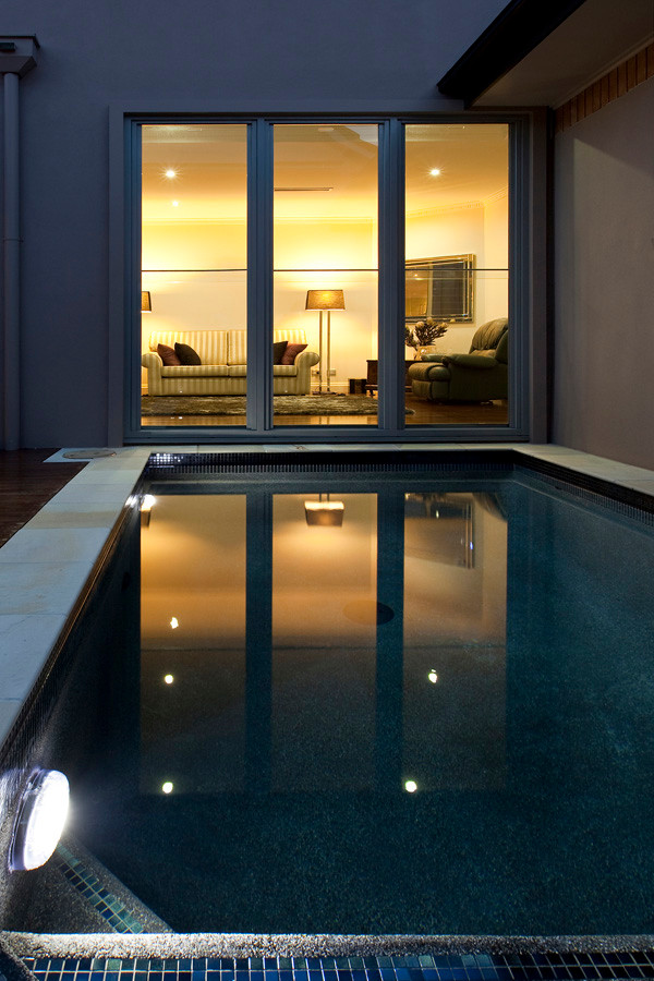Imagen de piscina actual extra grande rectangular en patio trasero con entablado