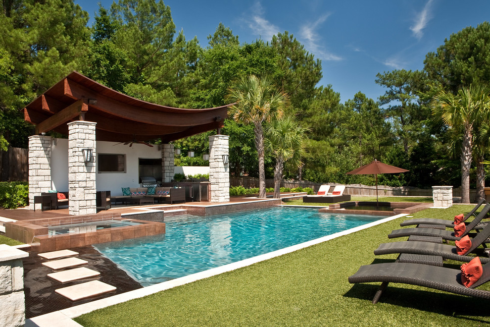 Ispirazione per una piscina tropicale rettangolare dietro casa con pedane