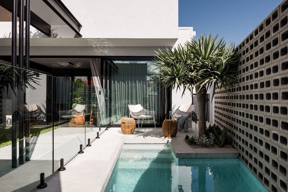 Foto di una piscina design personalizzata di medie dimensioni e in cortile con lastre di cemento