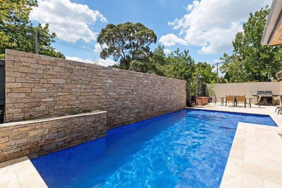 Idéer för en liten medelhavsstil pool längs med huset, med naturstensplattor