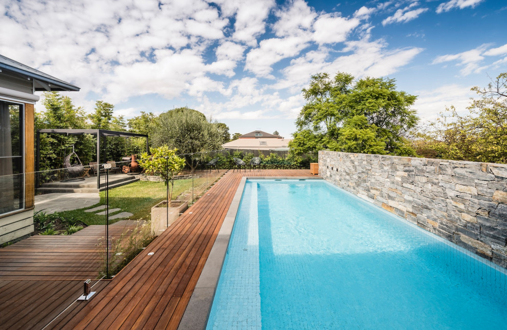 Inspiration for a medium sized contemporary back rectangular above ground swimming pool in Melbourne with natural stone paving and with pool landscaping.