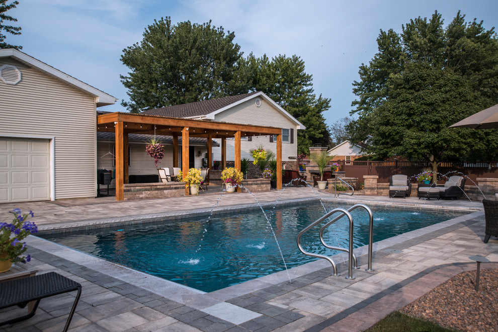 На фото: спортивный, прямоугольный бассейн среднего размера на заднем дворе в классическом стиле с домиком у бассейна и мощением тротуарной плиткой
