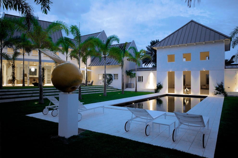 Modelo de piscina contemporánea extra grande rectangular en patio con adoquines de piedra natural