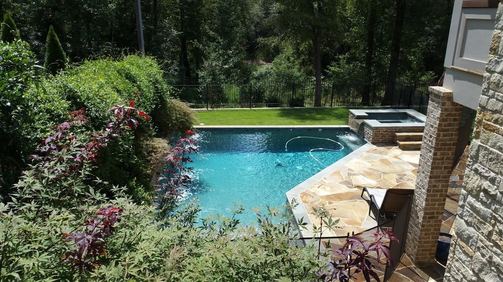 Foto de piscinas y jacuzzis naturales clásicos renovados grandes a medida en patio trasero con adoquines de piedra natural