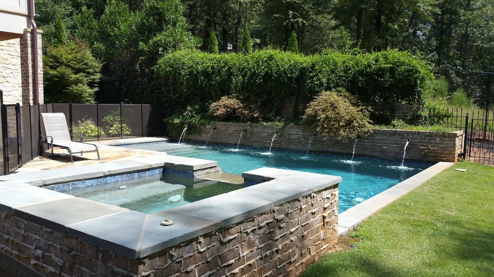 Imagen de piscinas y jacuzzis naturales tradicionales renovados grandes rectangulares en patio trasero con adoquines de hormigón