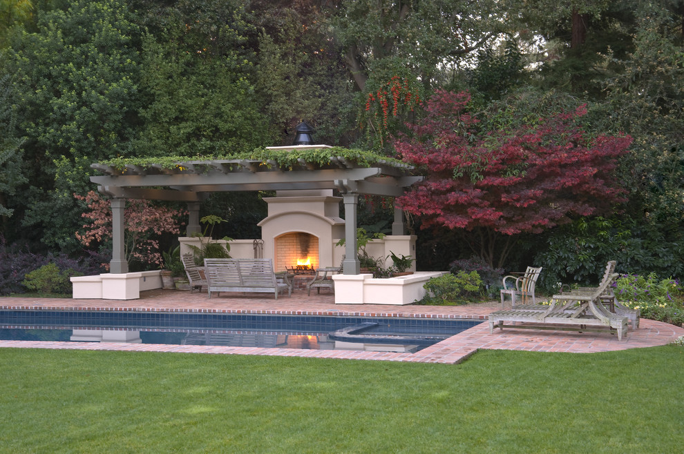 Modelo de piscina alargada clásica de tamaño medio rectangular en patio trasero con adoquines de ladrillo