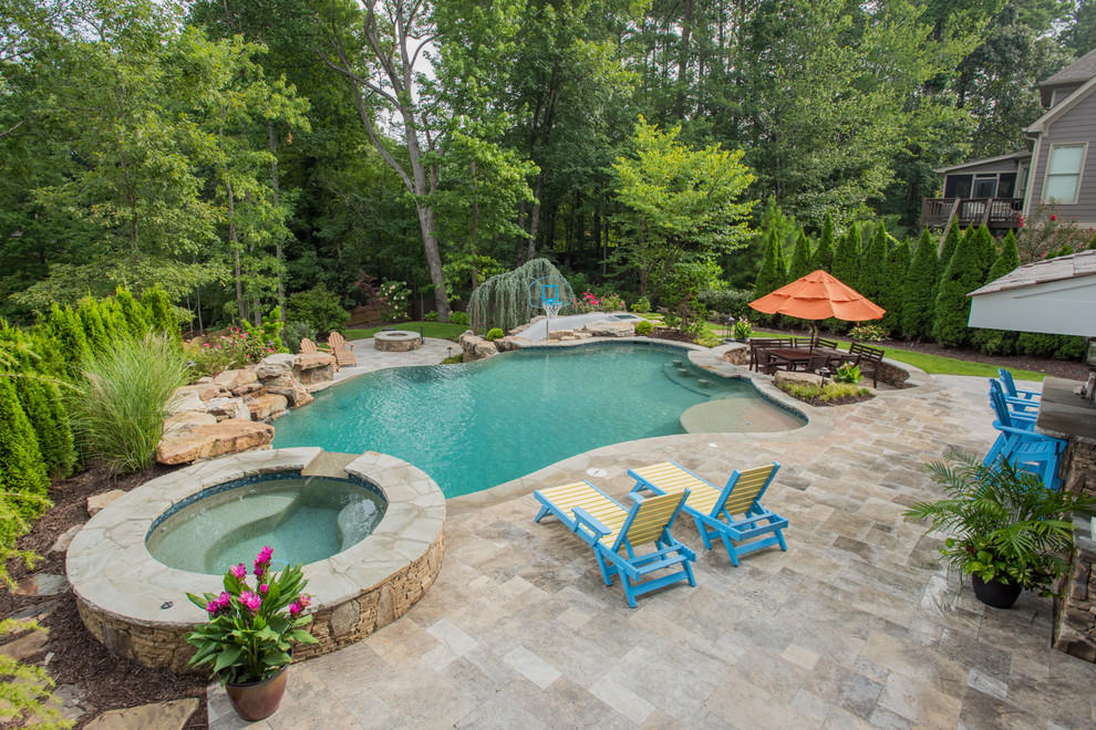 Inspiration for an expansive world-inspired back custom shaped infinity swimming pool in Atlanta with a water slide and natural stone paving.