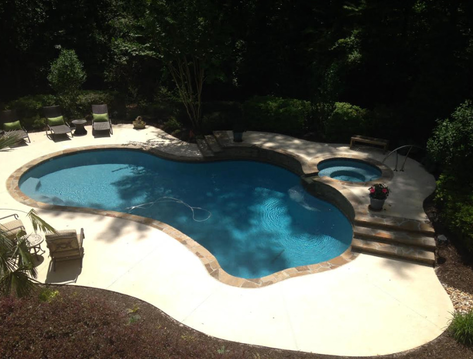 Ispirazione per una piscina chic personalizzata di medie dimensioni e dietro casa con pavimentazioni in pietra naturale