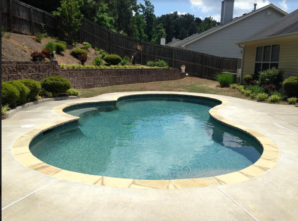 Small transitional backyard stone and custom-shaped pool photo in Atlanta