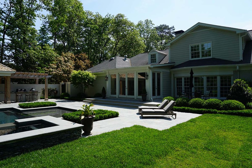Large elegant backyard concrete paver and custom-shaped natural hot tub photo in Atlanta