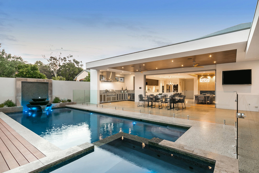 Contemporary back rectangular lengths swimming pool in Perth with decking and a bbq area.