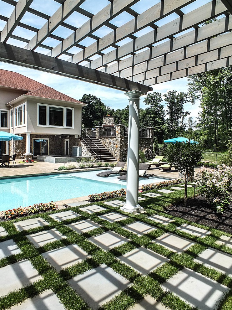 Imagen de piscina minimalista grande rectangular en patio trasero con adoquines de hormigón