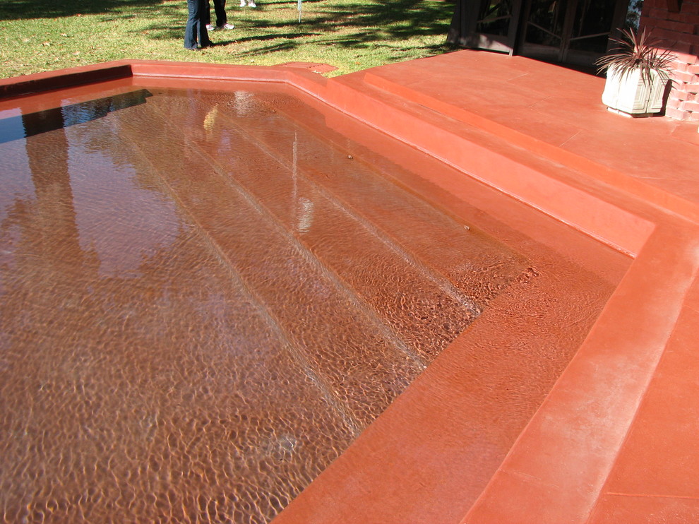 Ejemplo de piscinas y jacuzzis alargados retro extra grandes rectangulares en patio lateral con losas de hormigón