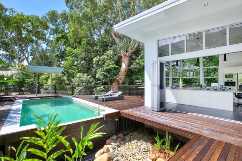 Foto de piscina con fuente infinita actual de tamaño medio rectangular en patio delantero con entablado