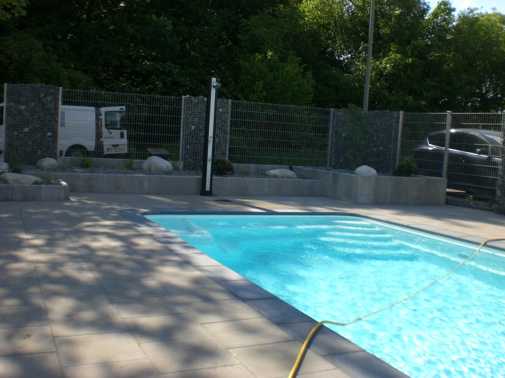Ispirazione per una grande piscina fuori terra contemporanea rettangolare dietro casa con una dépendance a bordo piscina e pavimentazioni in mattoni