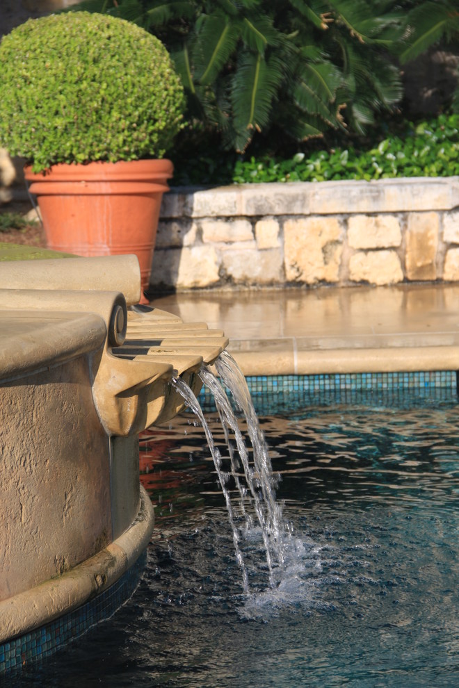 Example of a mid-sized tuscan stone and rectangular hot tub design in Austin