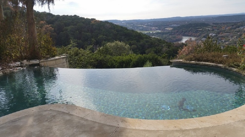 Photo of a medium sized modern back kidney-shaped above ground swimming pool in Austin with natural stone paving.