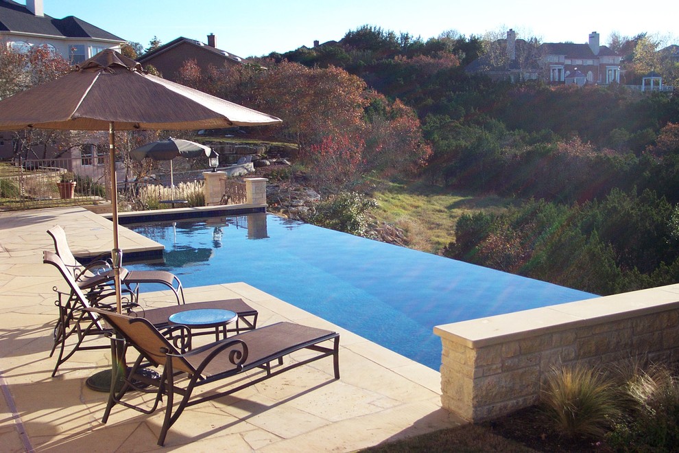 Стильный дизайн: большой прямоугольный бассейн-инфинити на заднем дворе в современном стиле с покрытием из каменной брусчатки - последний тренд
